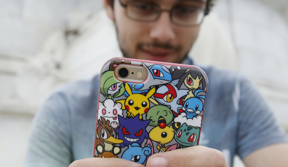 A man holds a phone with Pokemon branding on its case