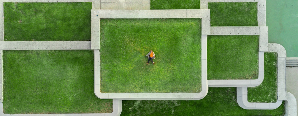 Man laying in a set of concentric grass fields
