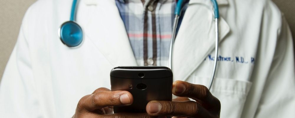 doctor holding phone telehealth
