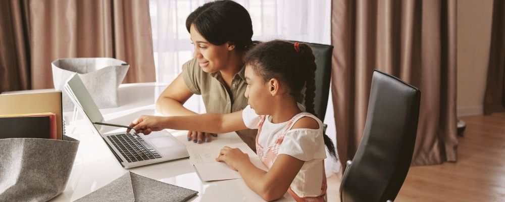 mother helping daughter with homework Online education eLearning